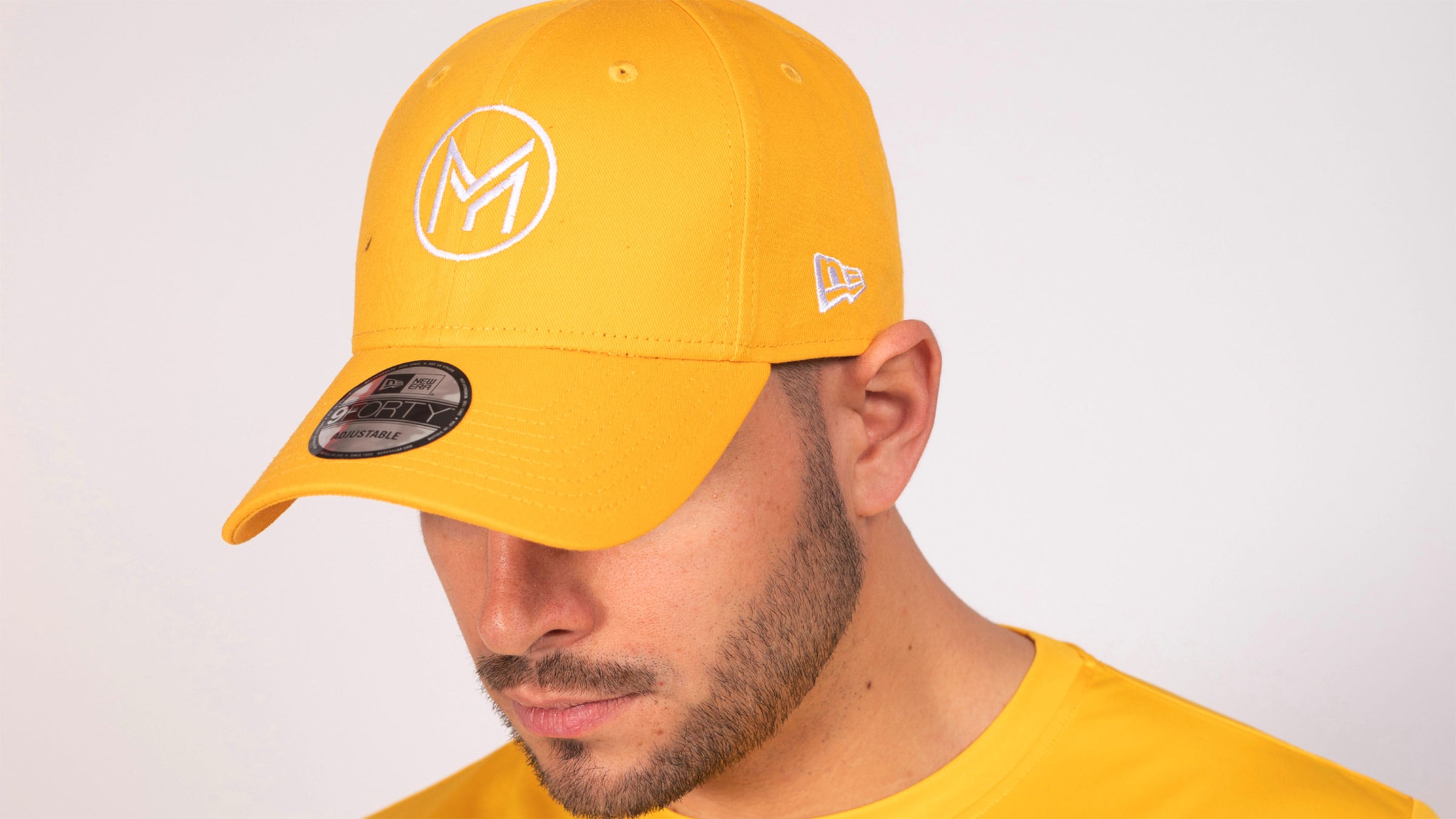 gros plan sur la tête d'un homme avec un t-shirt jaune et une casquette de la marque Mucho